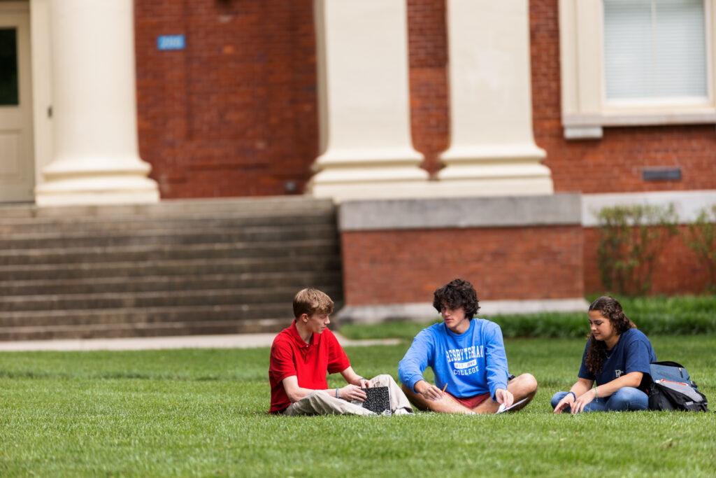 Three pC students sitting on the lawn.