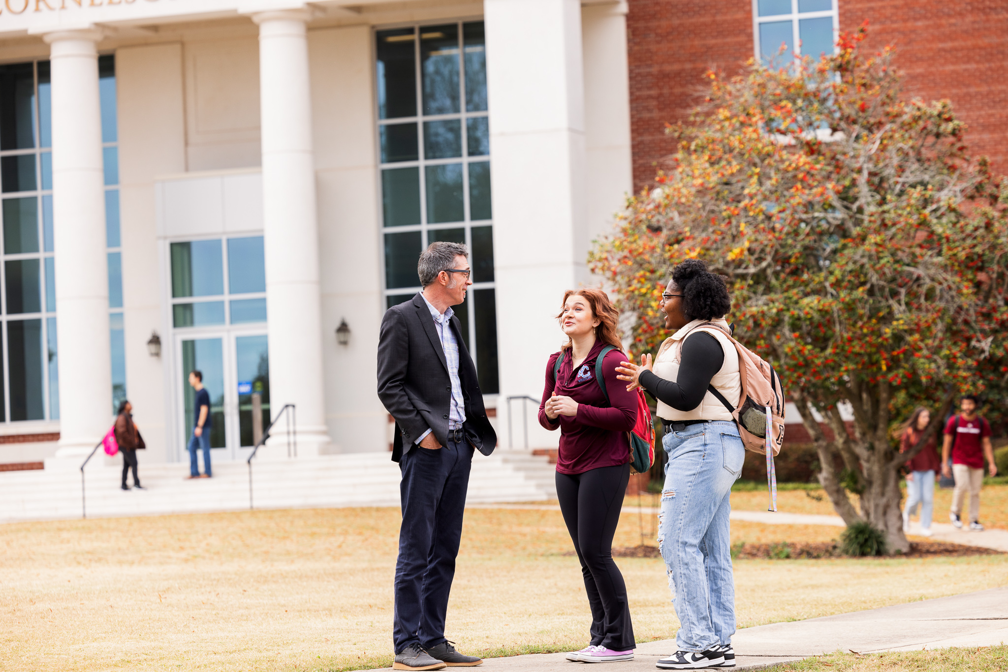 Presbyterian College students talking with a professor outside of Neville Hall.
