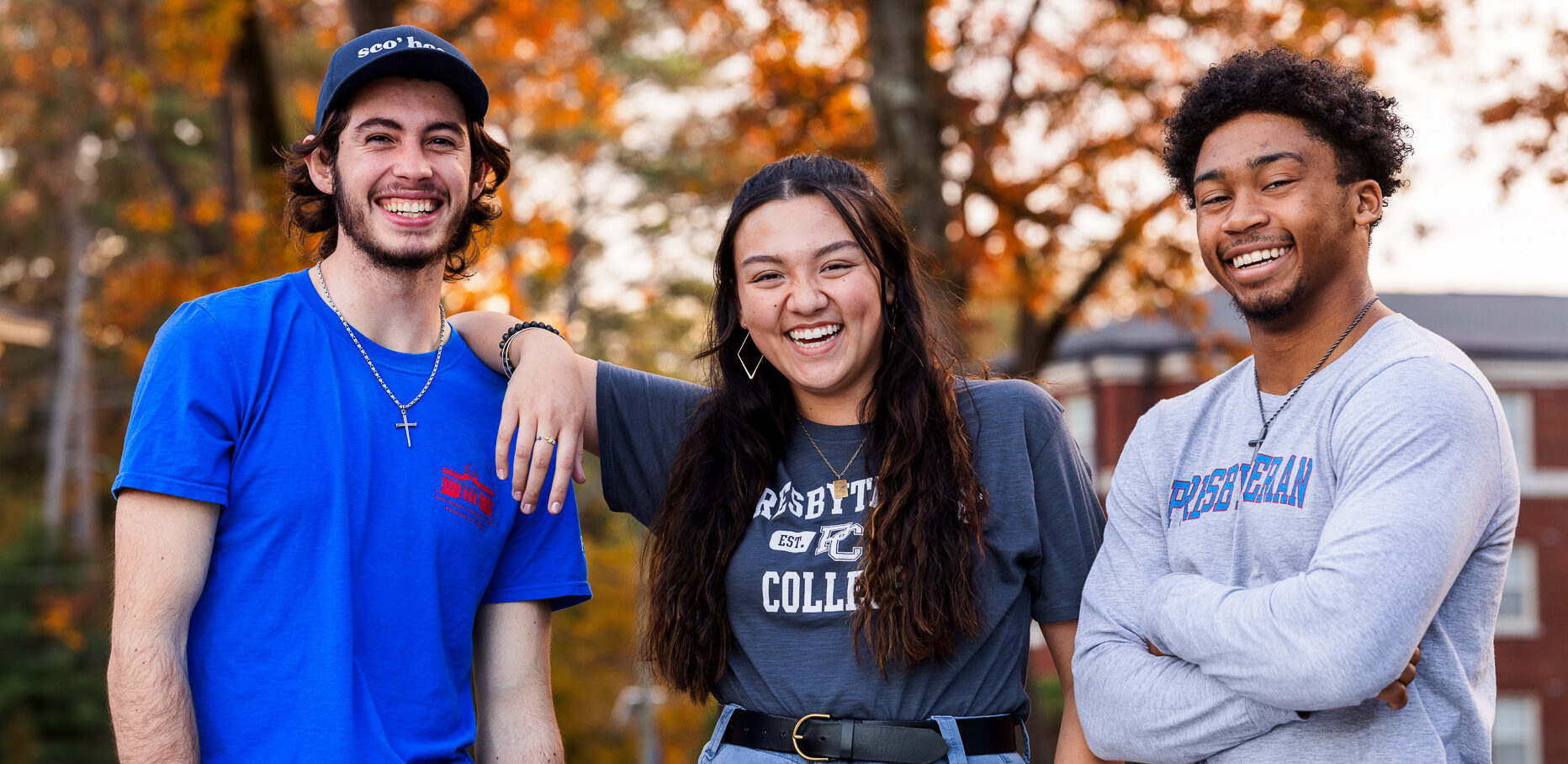 Three Presbyterian College students smiling on campus.