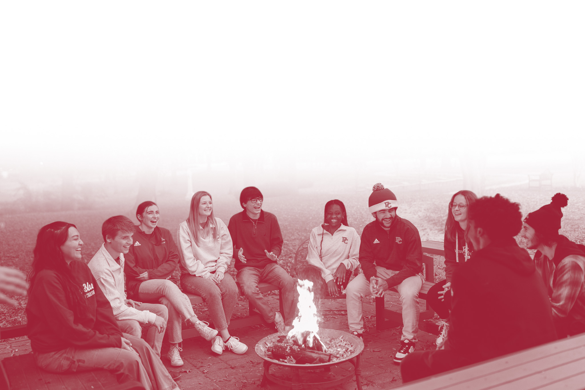 Presbyterian College students sitting around a bonfire.