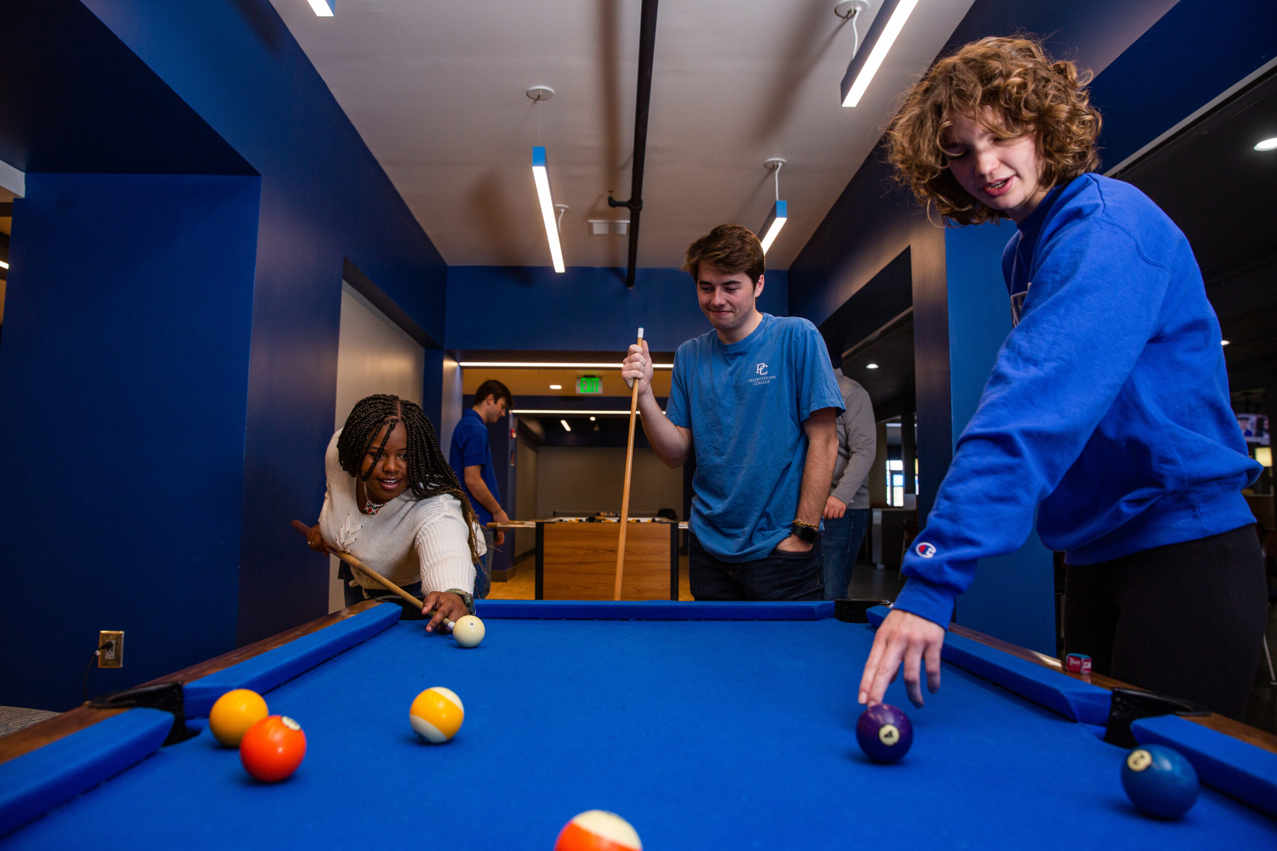 Students playing pool on a blue PC pool table
