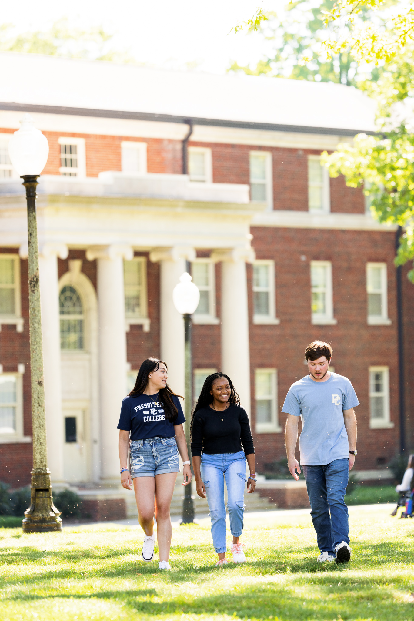 Presbyterian College students walking through campus on a sunny day.