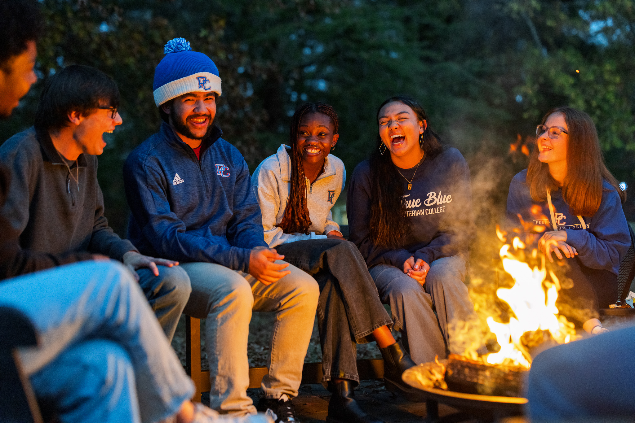 Presbyterian College students hanging out around a bonfire.