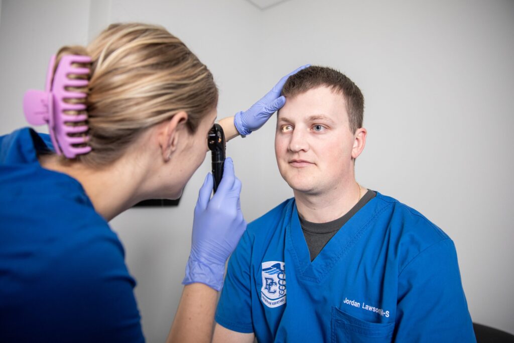 Presbyterian College PA students conducting an eye exam.