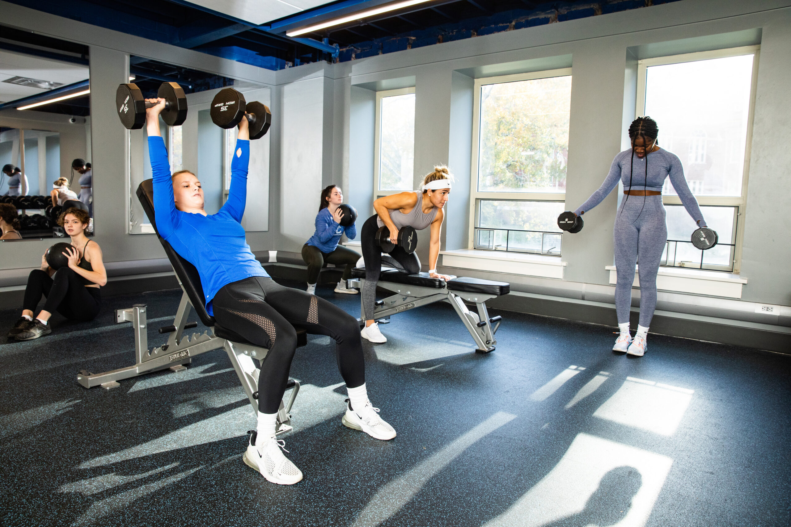 People lifting weights in the fitness room at Springs.