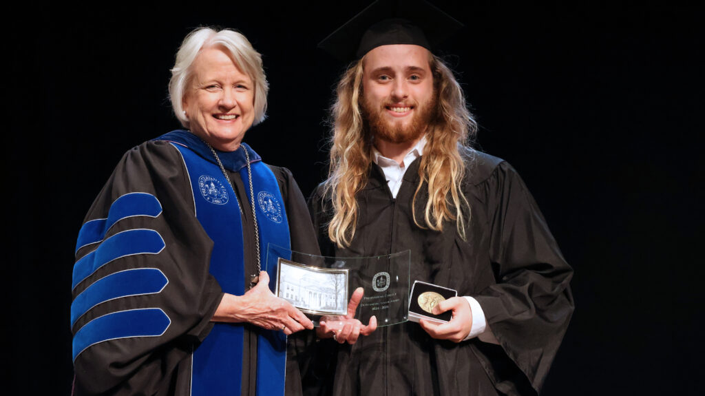 President Gustafson handing an award to Patrick Buchanan. 