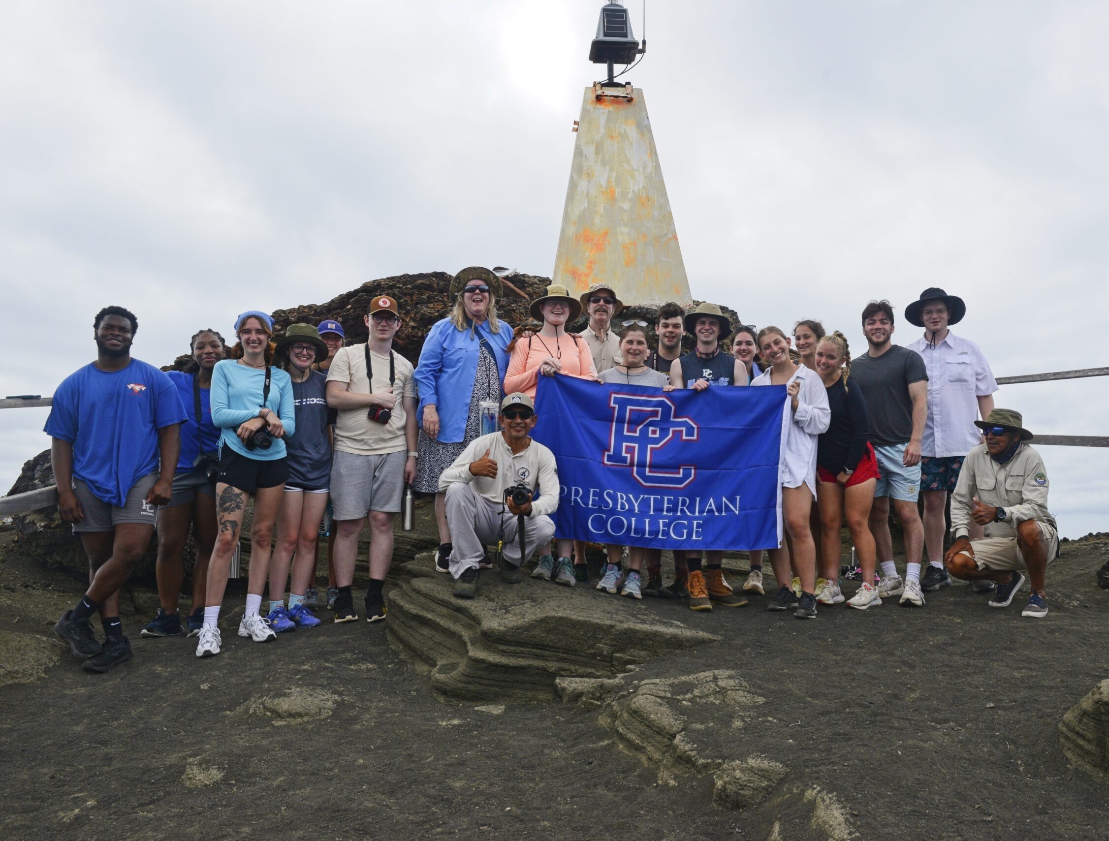 Group of students posing with a Presbyterian College flag.