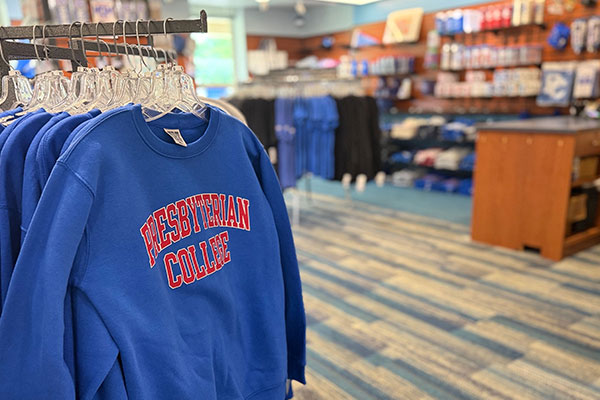 Closeup shot of Presbyterian College sweatshirts on a rack (with other products out of focus in the background) in the Scotsman's Corner spirit store in Springs Student Center